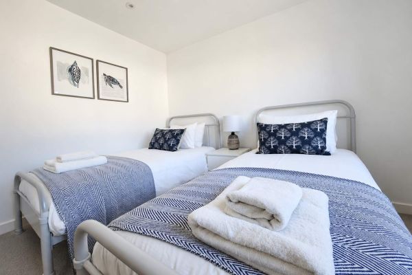Guest-ready twin bedroom with fresh towels after holiday let cleaning in Dorset