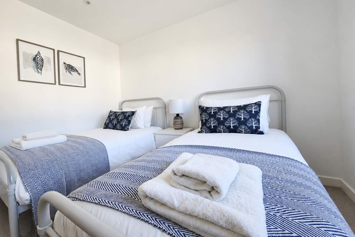 Guest-ready twin bedroom with fresh towels after holiday let cleaning in Dorset